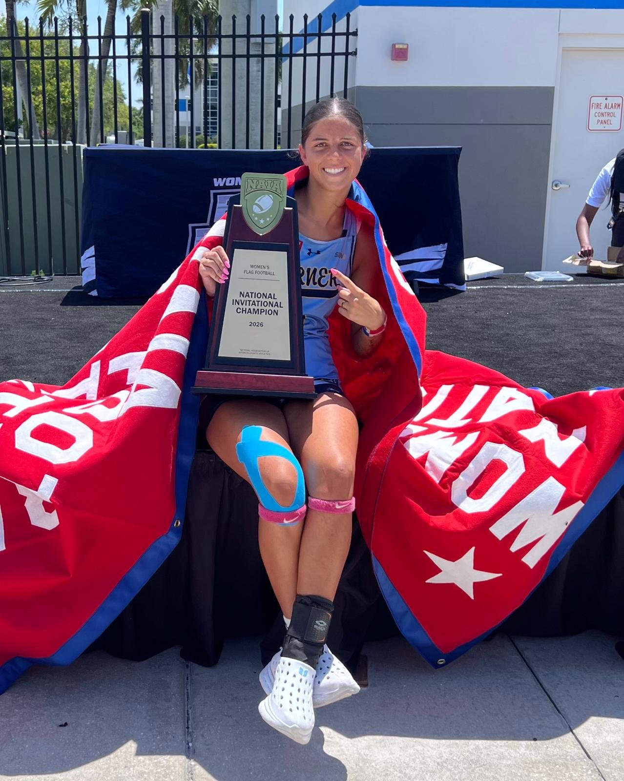 Kayleigh Thomas holding the 2026 National Invitational Champion trophy
